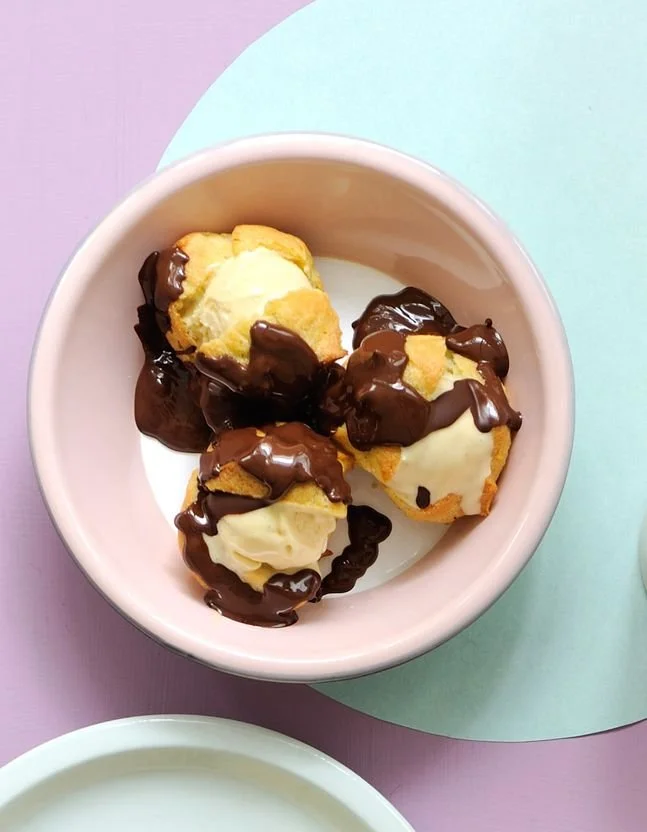 Profiteroles délicieuses garnies de crème et nappées de chocolat
